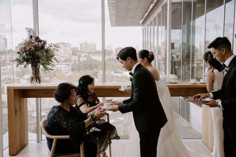 KWH real bride Sarah and Brian bowing to their mothers for their tea ceremony. She wears the traditonal Kitty Joni gown.