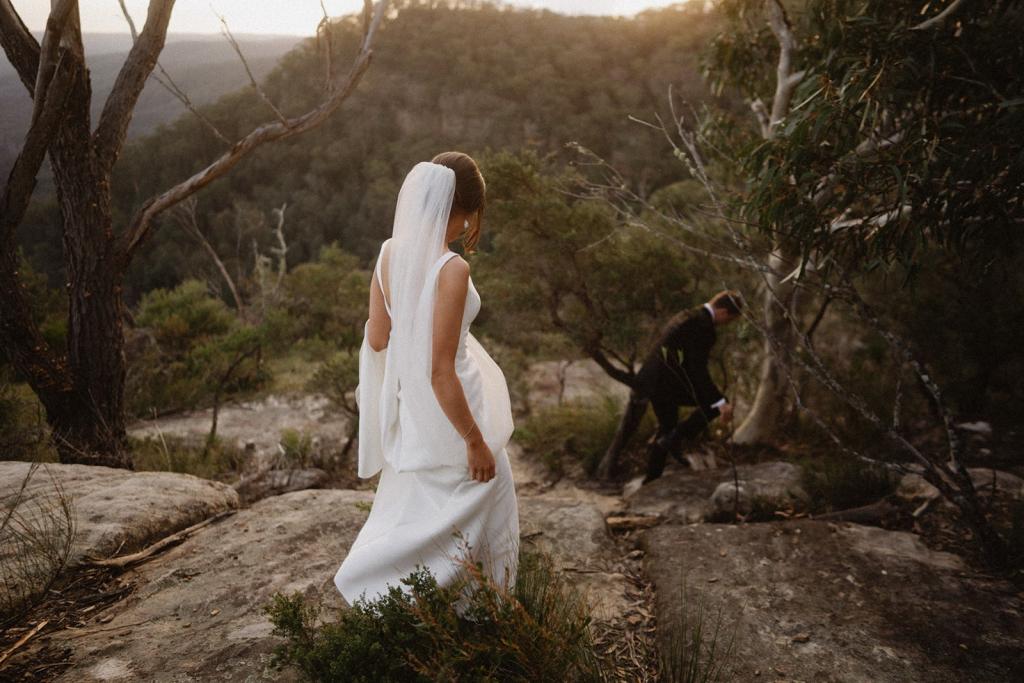 Real bride Charlotte walking into the hills with her new husband. She wears the effortless Leonie Alexia gown by KWH.