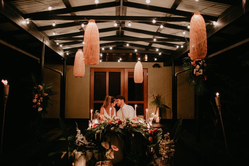 KWH real bride Jana and Garret popping a bottle of champagne. She wears the two piece Erin and Lea bridal combo featuring an aline skirt and fitted vneck bodice.