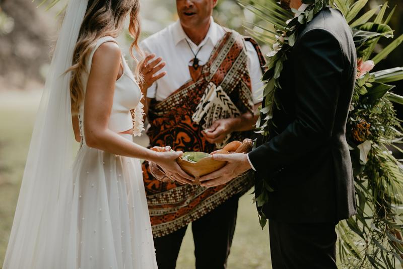 KWH real bride Jana and Garret walk out of their quaint Hawaiian bungalow to their ceremony. She wears the contemporary Erin and Lea wedding dress set with seperate pieces.