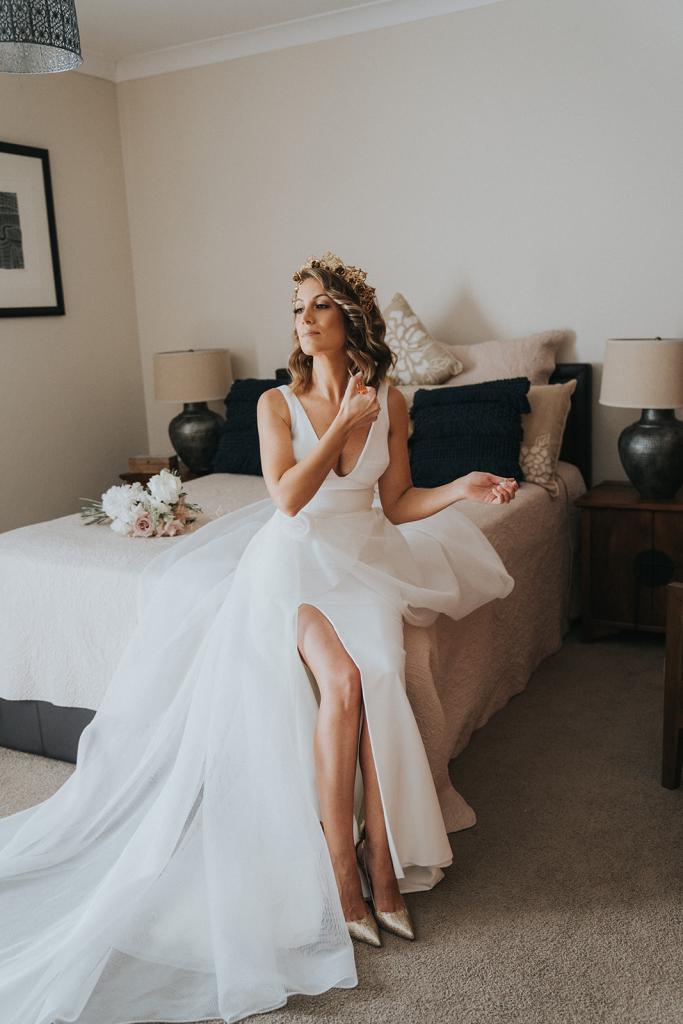 KWH real bride Talia spritz herself with fresh perfume as she wears the modern a-line wedding dress with Ushaped neckline.