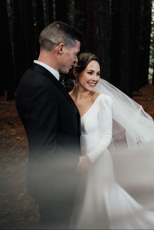 KWH real bride dancing in the woods with her new husband. She wears the comfortable Aubrey wedding dress made from crepe with a fitted silhouette.