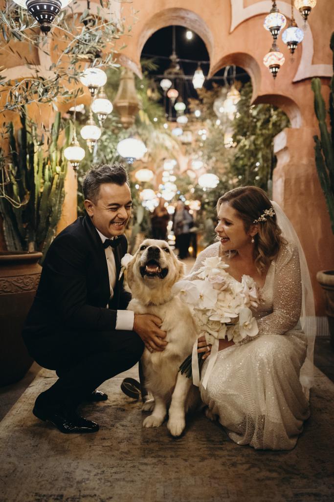KWH real bride Emily and Mark bent down to hug their golden retriver. She wears the timeless Celine wedding dress.
