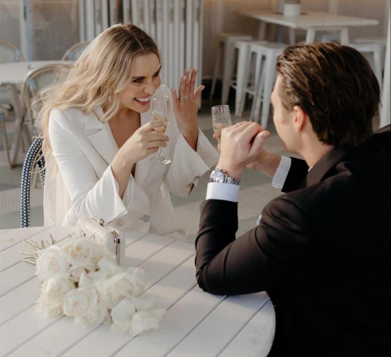 KWH real bride Demi and James stand on the shore. She wears the sleek Charlie Danielle bridal suit with wide leg for her modern elopement.