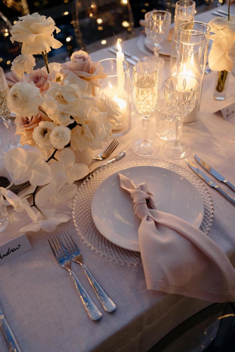 KWH real bride Demi's small reception table style with blush linens, white roses and crystal glasses.