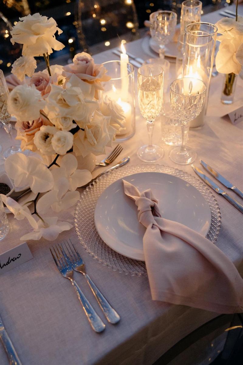 KWH real bride Demi's reception decor for their elopement with blush pinks and string lights over a long banquet table.