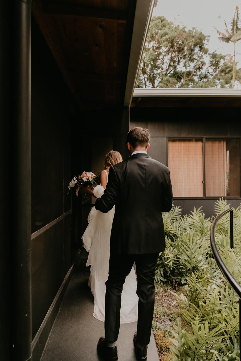 KWH real bride Jana and Garret walk out of their quaint Hawaiian bungalow to their ceremony. She wears the contemporary Erin and Lea wedding dress set with seperate pieces.