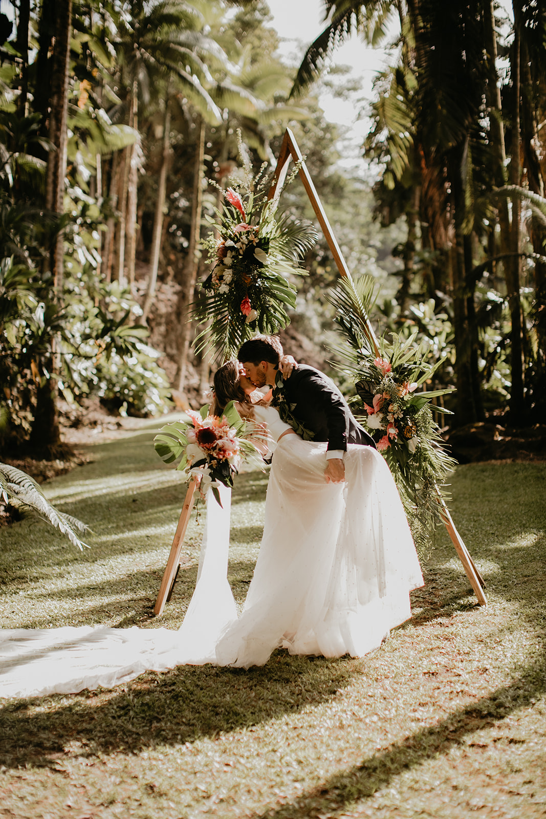 KWH real bride Jana and Garret kiss at their modern ceremony alter adorned with native flowers. She wears the modern Erin and Lea wedding set with tulle skirt.