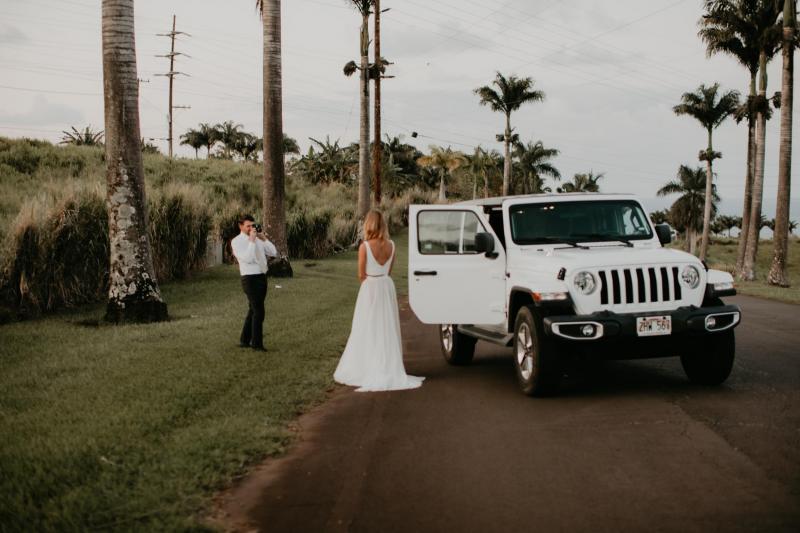 KWH real bride Jana dances in her Erin and Lea two piece wedding dress set in front of the headlights of a jeep after her modern elopement.