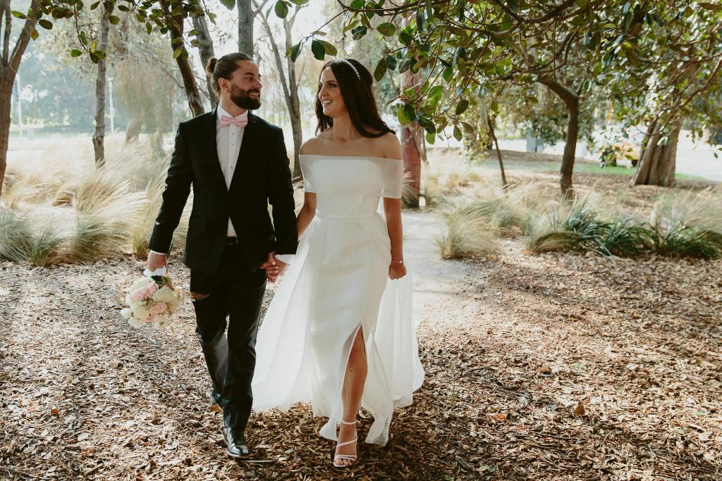 KWH real bride Libby walks through the forest with her new hubby. She wears the ivory Esther wedding dress which is strapless with mesh collar overlay.