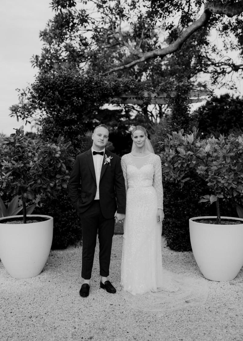 KWH real bride Taylor walking in her sweetheart neckline Lexie wedding dress with a drink in her hand.