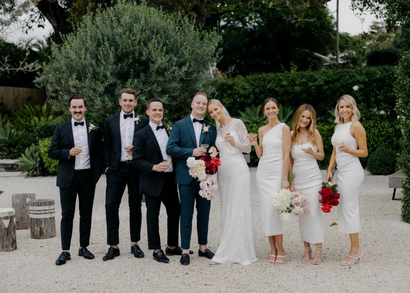 KWH real bride Taylor and Kalen under a clear umbrella. She wears the classic beaded Lexie wedding dress.