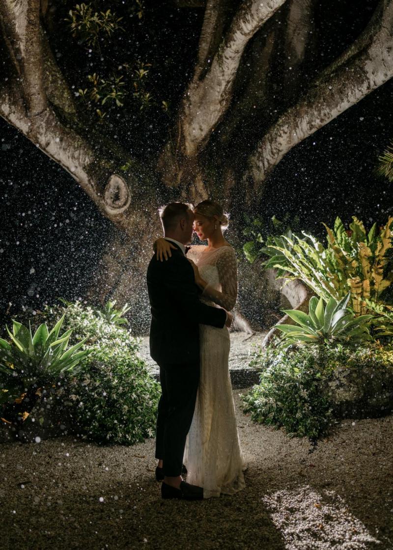 KWH real bride Taylor & Kalen dancing under the rain at night in her sequin Lexie wedding dress.