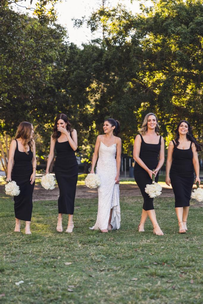 KWH real bride Ash with her bridesmaids who all wear ankle length black dress and white bouquets. Ash wears the ivory sequin Anya wedding dress.