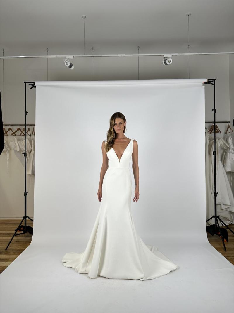 The Brooklyn & Jayde gown by Karen Willis Holmes, a plunging neckline simple wedding dress bodice with a simple fit and flare crepe wedding dress skirt.