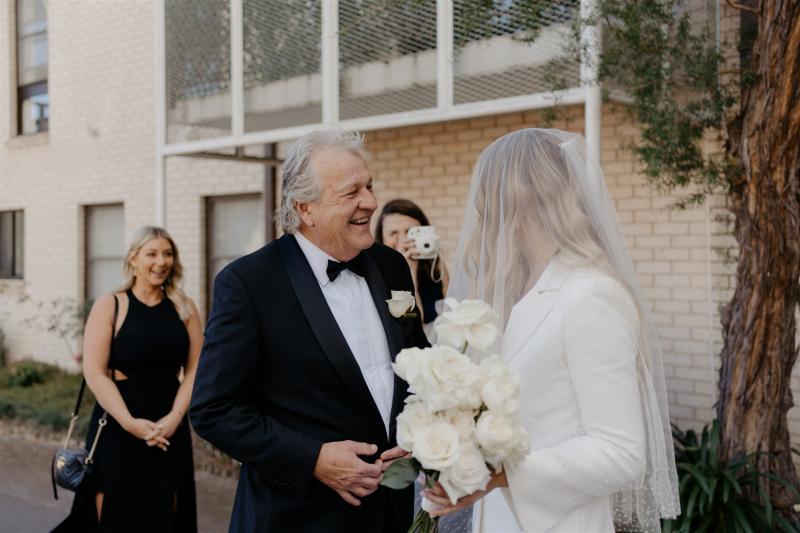 KWH real bride Demi sharing a moment with her father at the church. She wears the classic Charlie Danielle bridal suit for her elopement.