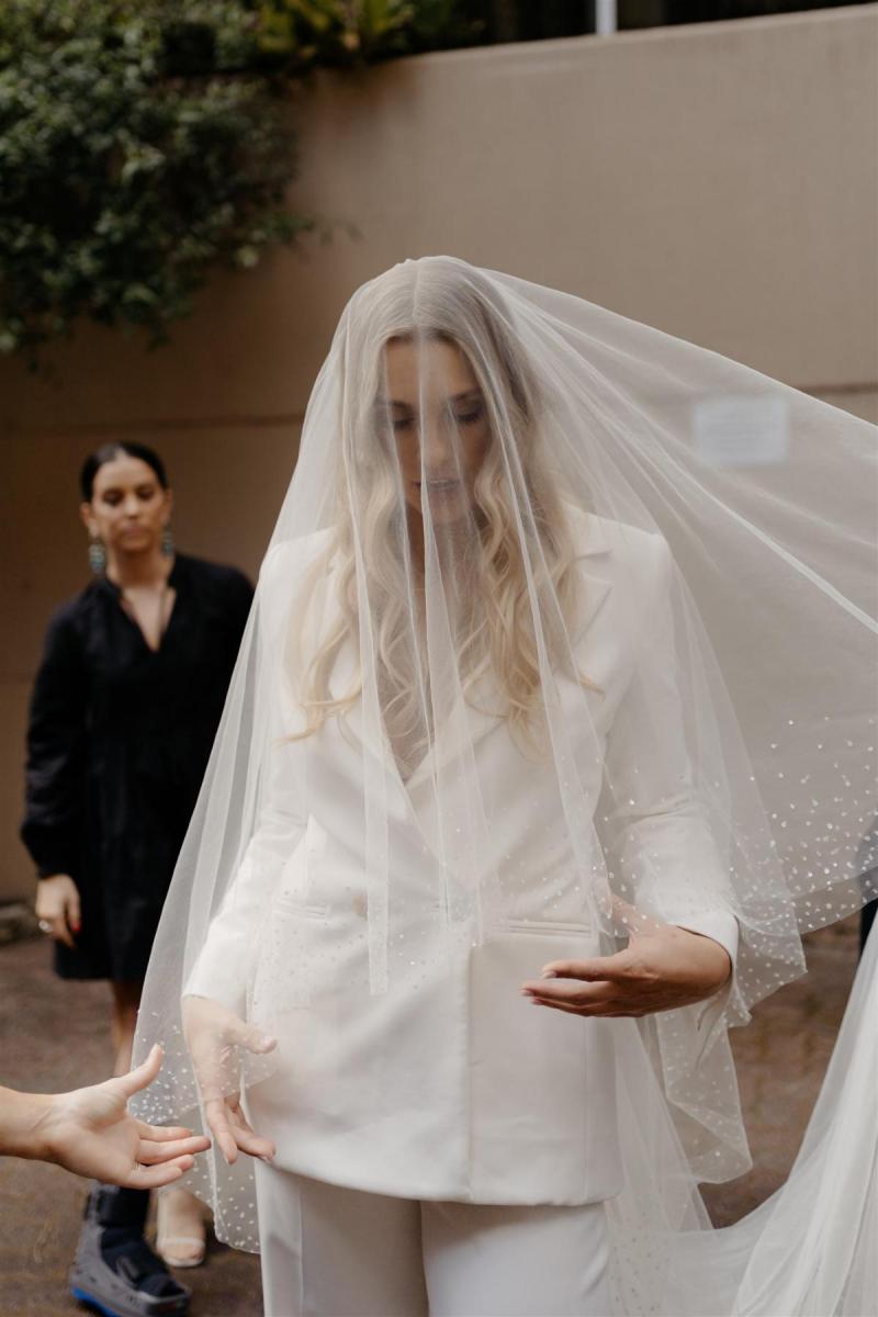 KWH real bride Demi wearing her Charlie and Danielle bridal suit, drapped in a simple Astra veil covering her face.