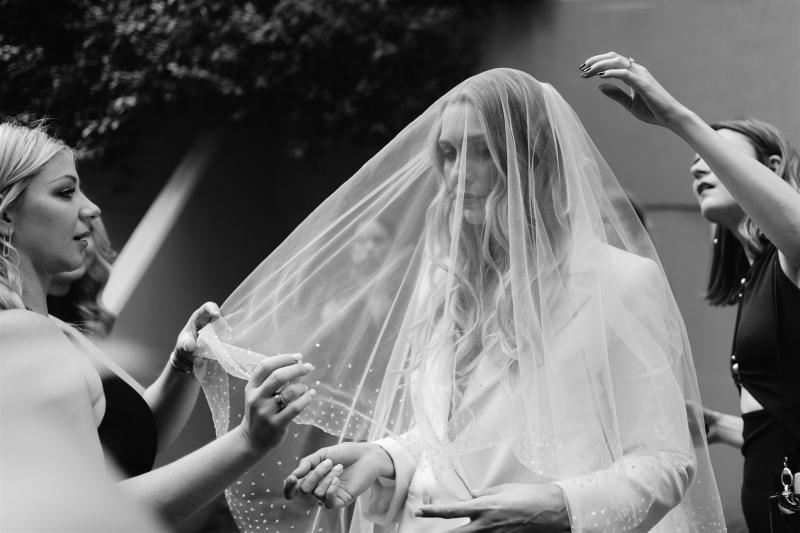 KWH real bride Demi wearing her Charlie and Danielle bridal suit, drapped in a simple Astra veil covering her face.