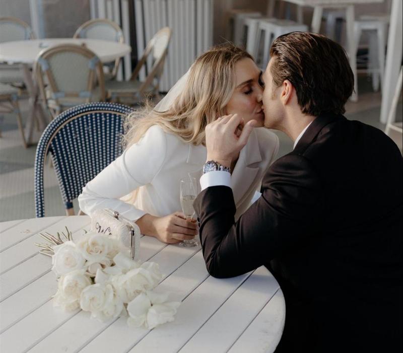 KWH real bride Demi and James stand on the shore. She wears the sleek Charlie Danielle bridal suit with wide leg for her modern elopement.