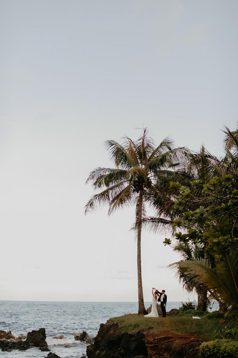 KWH real bride Jana and Garret dance under the palms of their destination elopement in Hawaii. She wears the modern Erin and Lea set with seperate bodice and skirt.