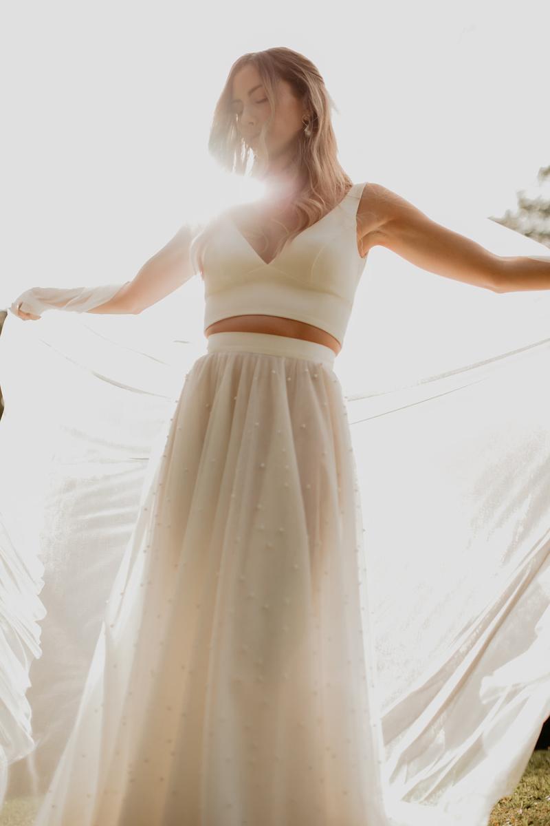 KWH real bride Jana dancing in the sun with her Erin and Lea two piece wedding dress. She plays with the tulle fabric of her Lea skirt.