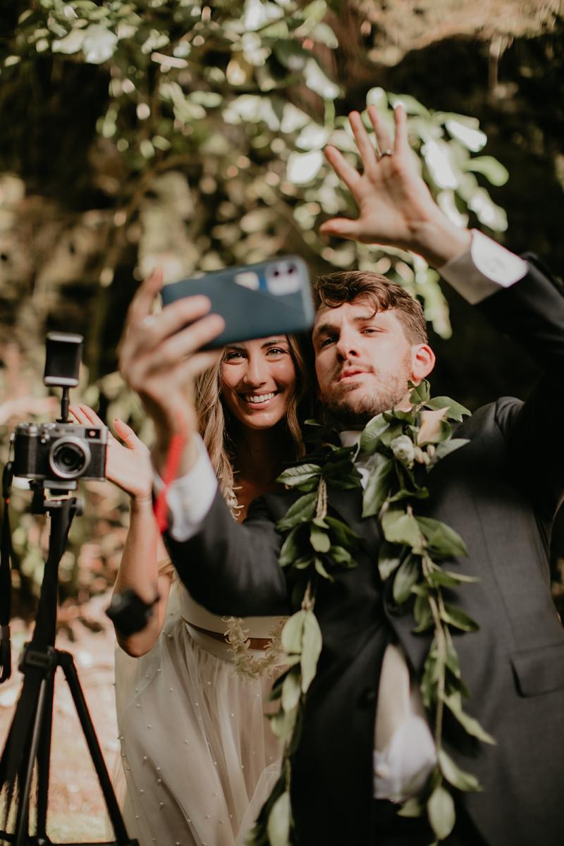 KWH real bride Jana and Garret looking at their matching rings. She wears the effortless Erin and Lea two piece wedding dress with pearl details.