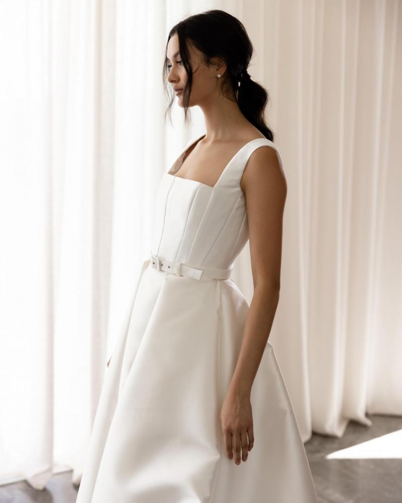 The Quinn bodice and Elizabeth Skirt by Karen Willis Holmes, a simple, straight neckline wedding dress with a traditional A line skirt with pockets with straps and an open back