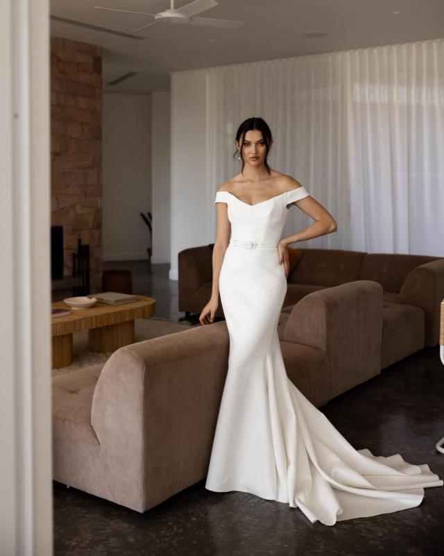 The Raven gown by Karen Willis Holmes, an off the shoulder fit and flare simple wedding dress.