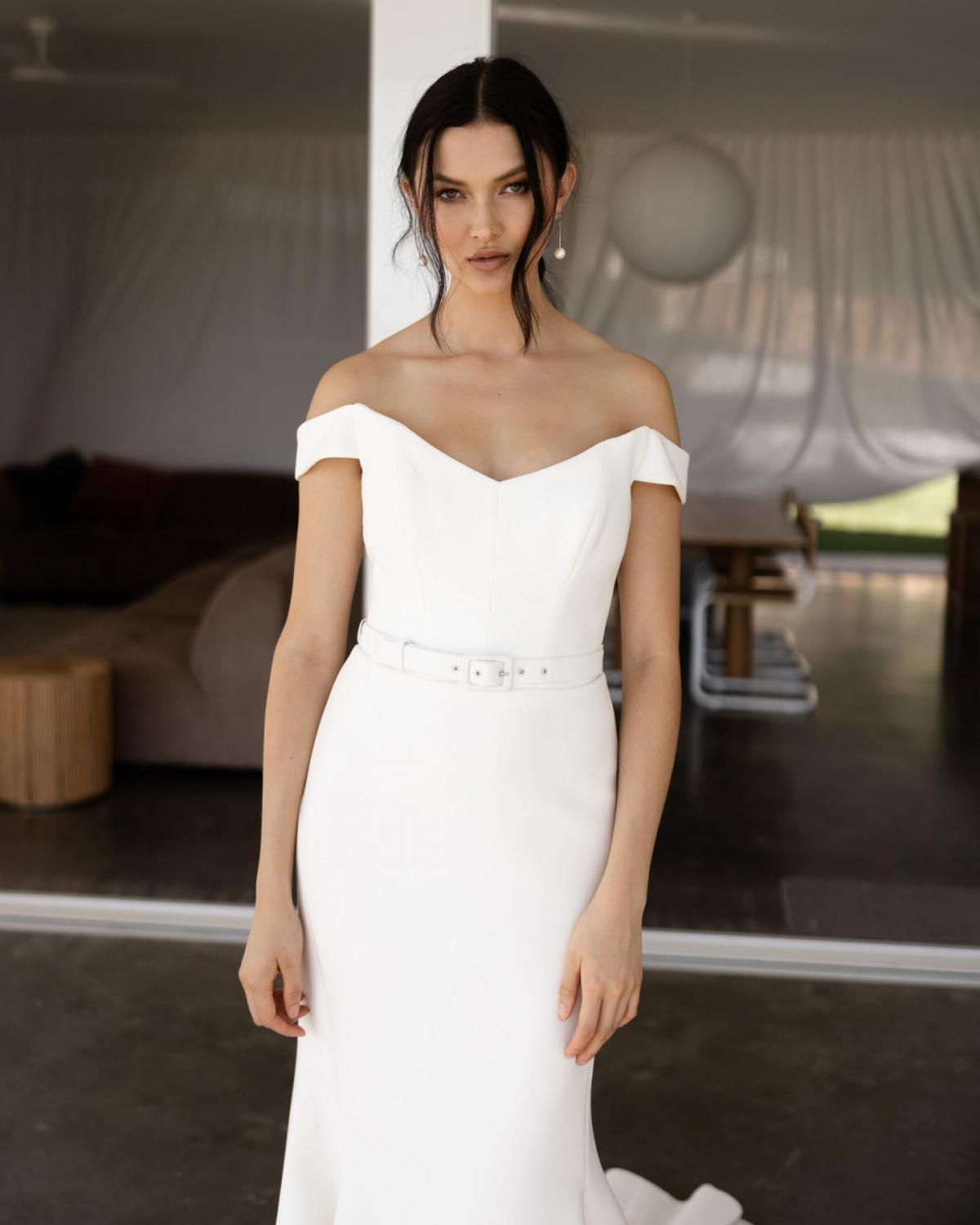 Upclose of the Raven gown by Karen Willis Holmes, an off the shoulder fit and flare simple wedding dress. with belt