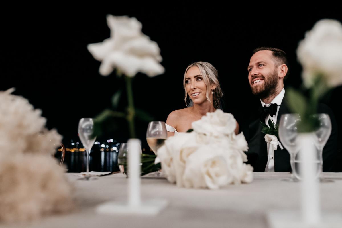 KWH real bride Genevieve and Kyle at their reception table outside. She wears the stunning Blake Camille wddding dress.