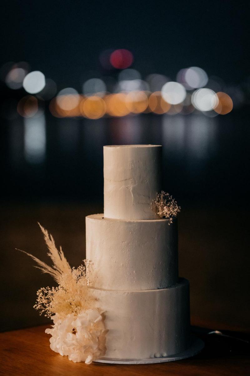 KWH real bride Genevive's minimalist wedding cake by Sukar. A light gray cake with dried flower.