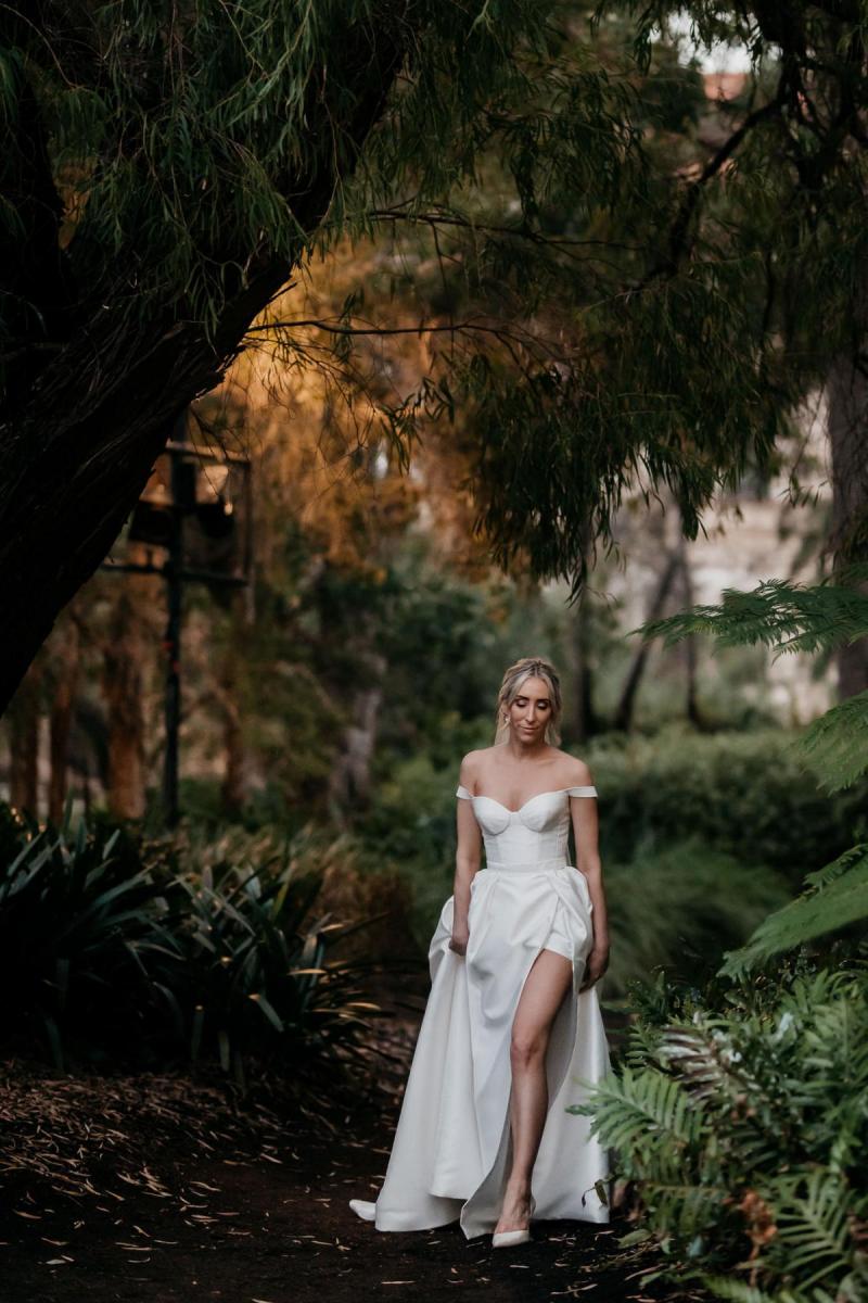KWH real bride Genevieve walking through the woods in her modern a-line Blake Camille wedding dress.