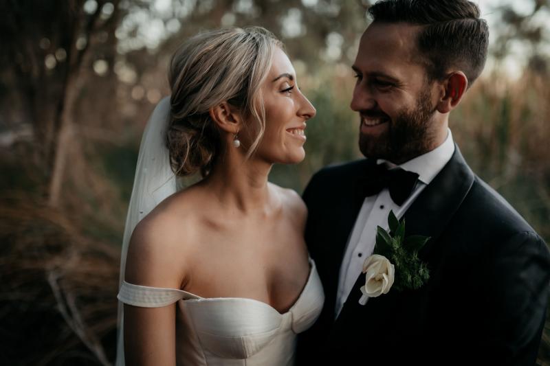 KWH real bride Genevieve walks through the woods with ballgown skirt and high leg split and bustier top.