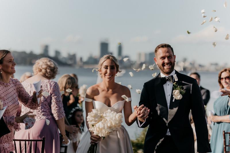 KWH real bride Genevieve and Kyle standing at their outdoor ceremony. She wore the timeless Blake Camille gown with structured bodice and aline skirt.