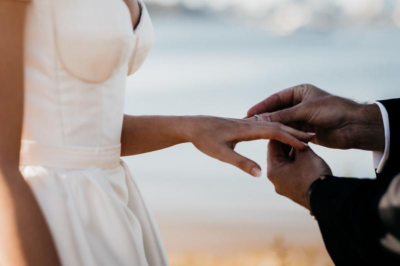 KWH real bride Genevieve and Kyle standing at their outdoor ceremony. She wore the timeless Blake Camille gown with structured bodice and aline skirt.