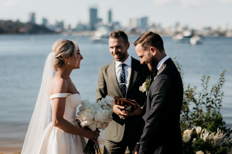 KWH real bride Genevieve and Kyle standing at their outdoor ceremony. She wore the timeless Blake Camille gown with structured bodice and aline skirt.