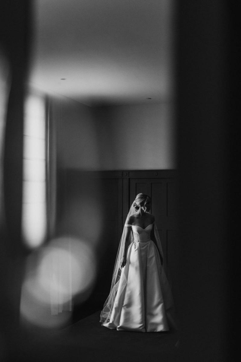 B&W image of KWH real bride Genevieve standing in her Blake Camille wedding dress; a aline wedding dress with pockets