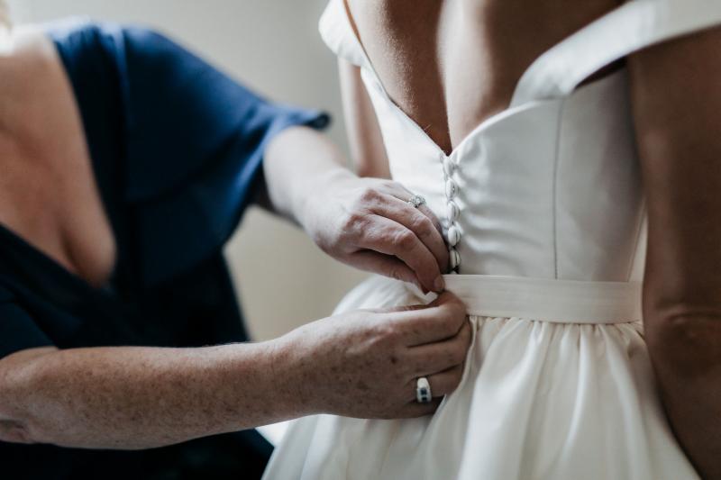 KWH real bride Genevieve's Blake Camille gown hanging up in the hotel room. Black Camille is an a-line wedding dress with structured bodice.