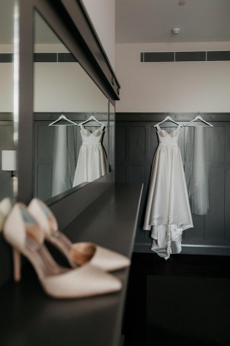 KWH real bride Genevieve's Blake Camille gown hanging up in the hotel room. Black Camille is an a-line wedding dress with structured bodice.
