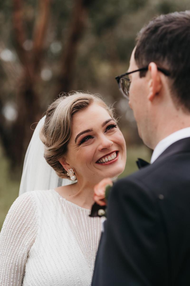 KWH real bride Nicola beams at her new husband. She wears the Cassie wedding dress with beaded illusion neckline.