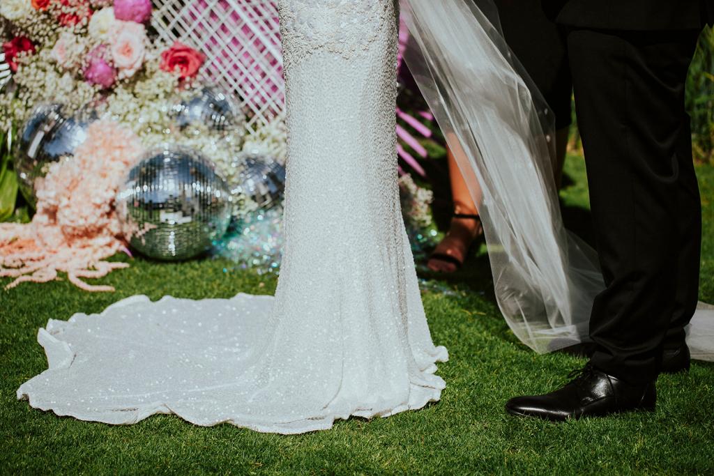 A close up shot of KWH real bride Jaz and Chris's wedding ceremony where she is wearing the Darcy gown, a modern beaded wedding dress with shoe string straps.
