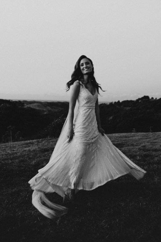 B&W image of KWH real bride Georgie twirling in her Fontanne gown, a fit and flare beaded wedding dress with long veil.