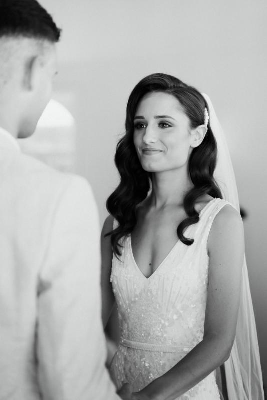 KWH real bride Georgie looks adoringly at Mikey at the alter. She wears the Fontanne gown, a hand-beaded V-neck wedding dress.