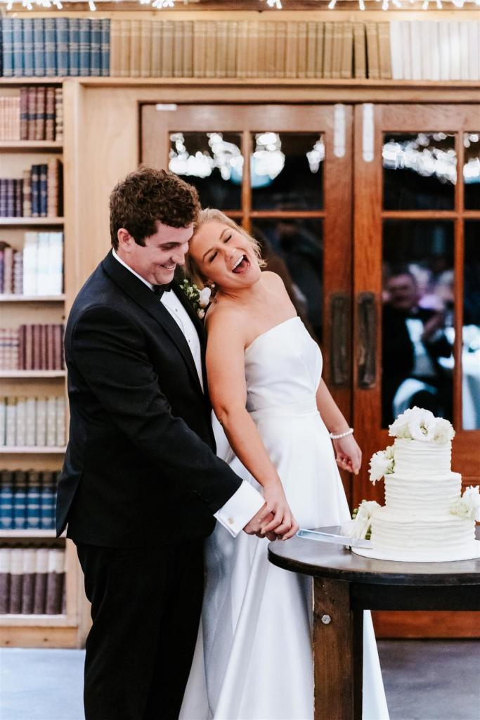 KWH real bride Annabelle and Will cutting their cake. She wears the classic Jacqueline Melanie gown, a straight-cut bodice and aline skirt wedding dress