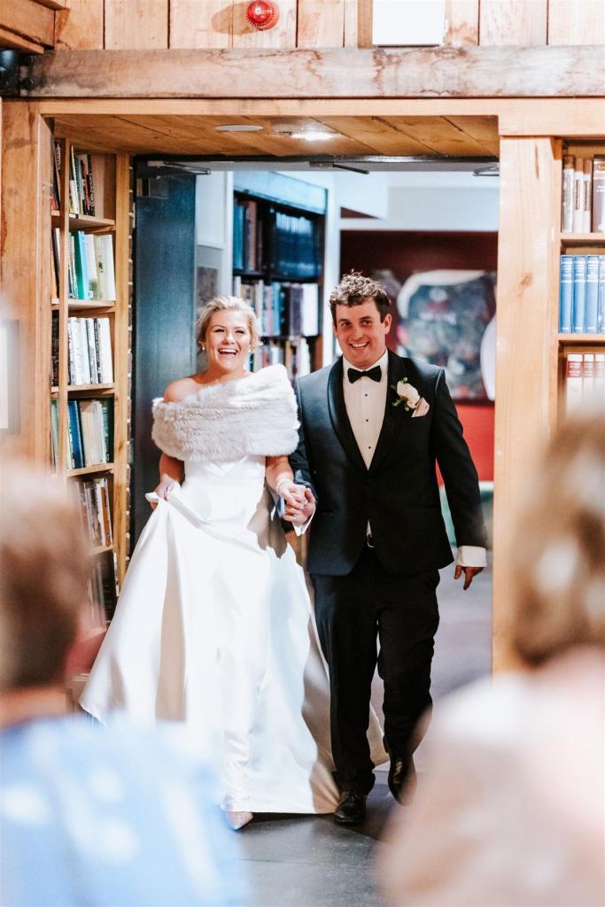 KWH real bride Annabelle and Will entering their rustic reception as she wears her timeless Jacqueline Melanie gown, a classic strapless a-line wedding dress.
