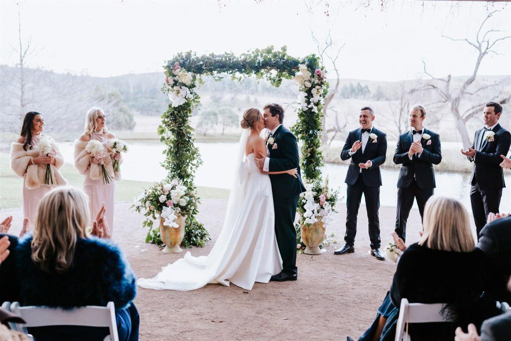 KWH real bride Annabelle kisses Will at their ceremony. She wears the Jacqueline Melanie gown, a modern ballgown wedding dress with strapless bodice.