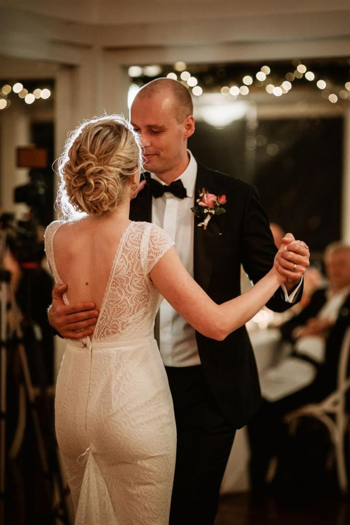 KWH real bride Gemma and Rob dancing at their simple reception. She wears the Jemma gown, a open back high neck lace wedding dress.