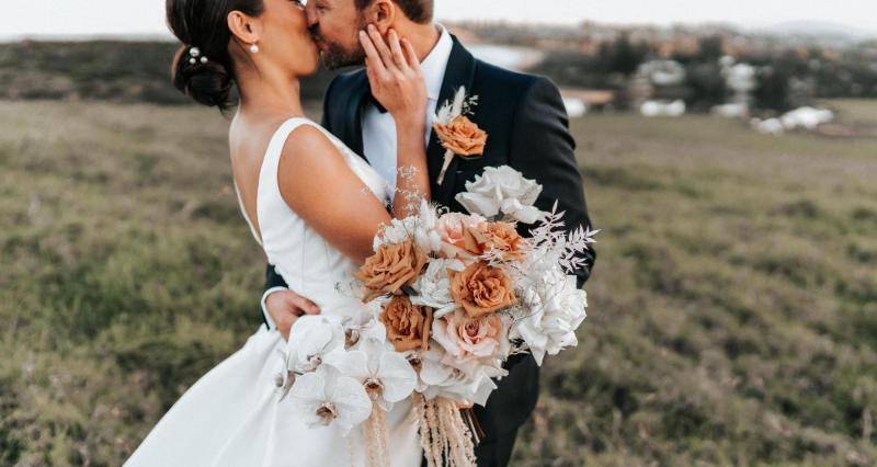 Burnt orange and light pink roses sit on the table at KWH real bride Rebecca's wedding.