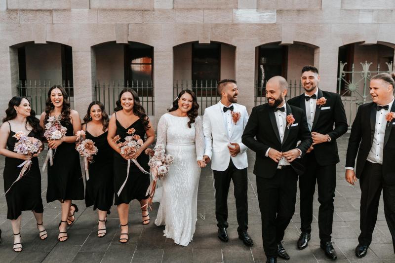 KWH real bride Katherine walks up the church stairs with Conor. She wears the gorgeous Margareta gown, a backless long sleeve beaded wedding dress.