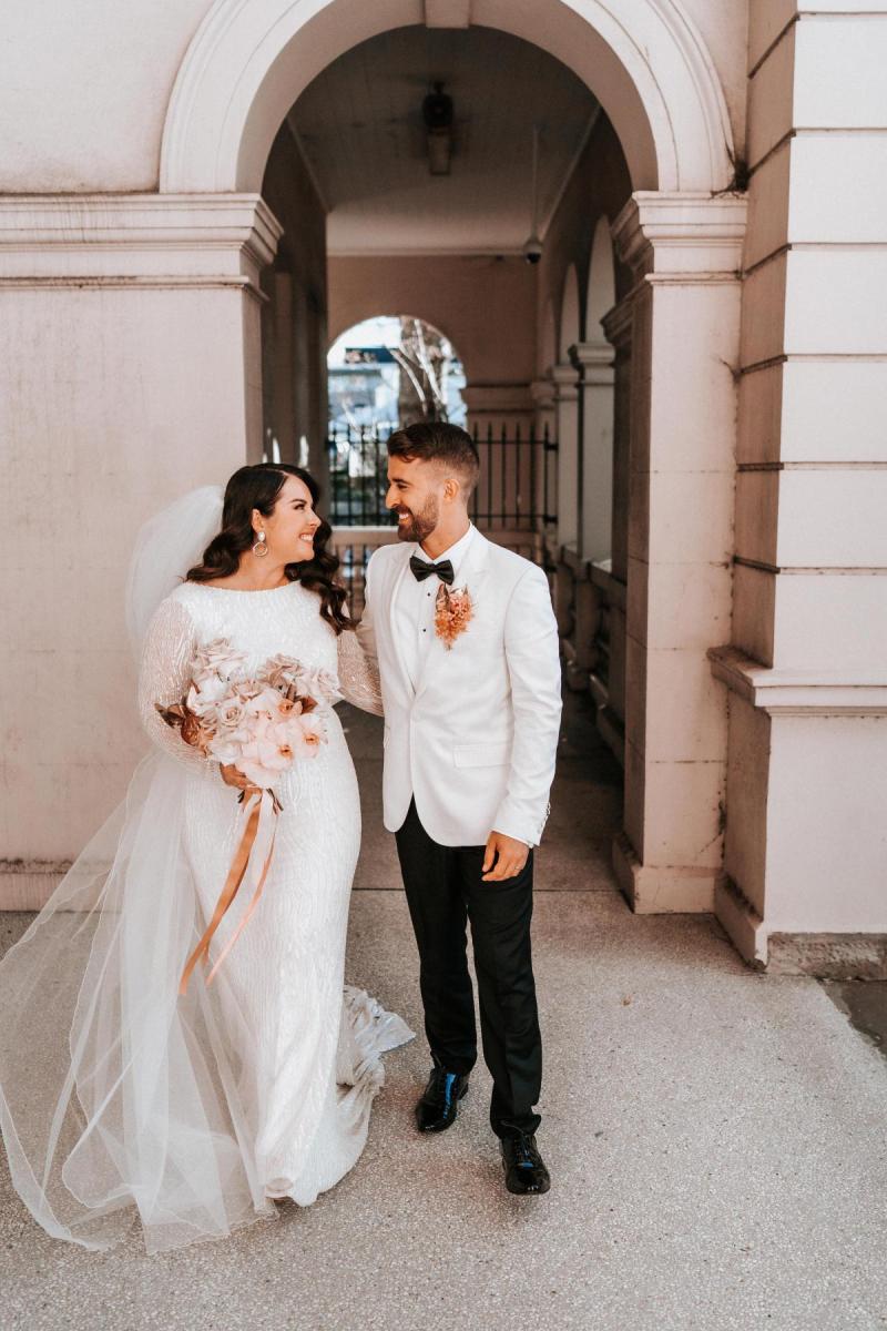 KWH real bride Kahterine and Conor looking at each other. She wears the Margareta gown, a high neck backless wedding dress